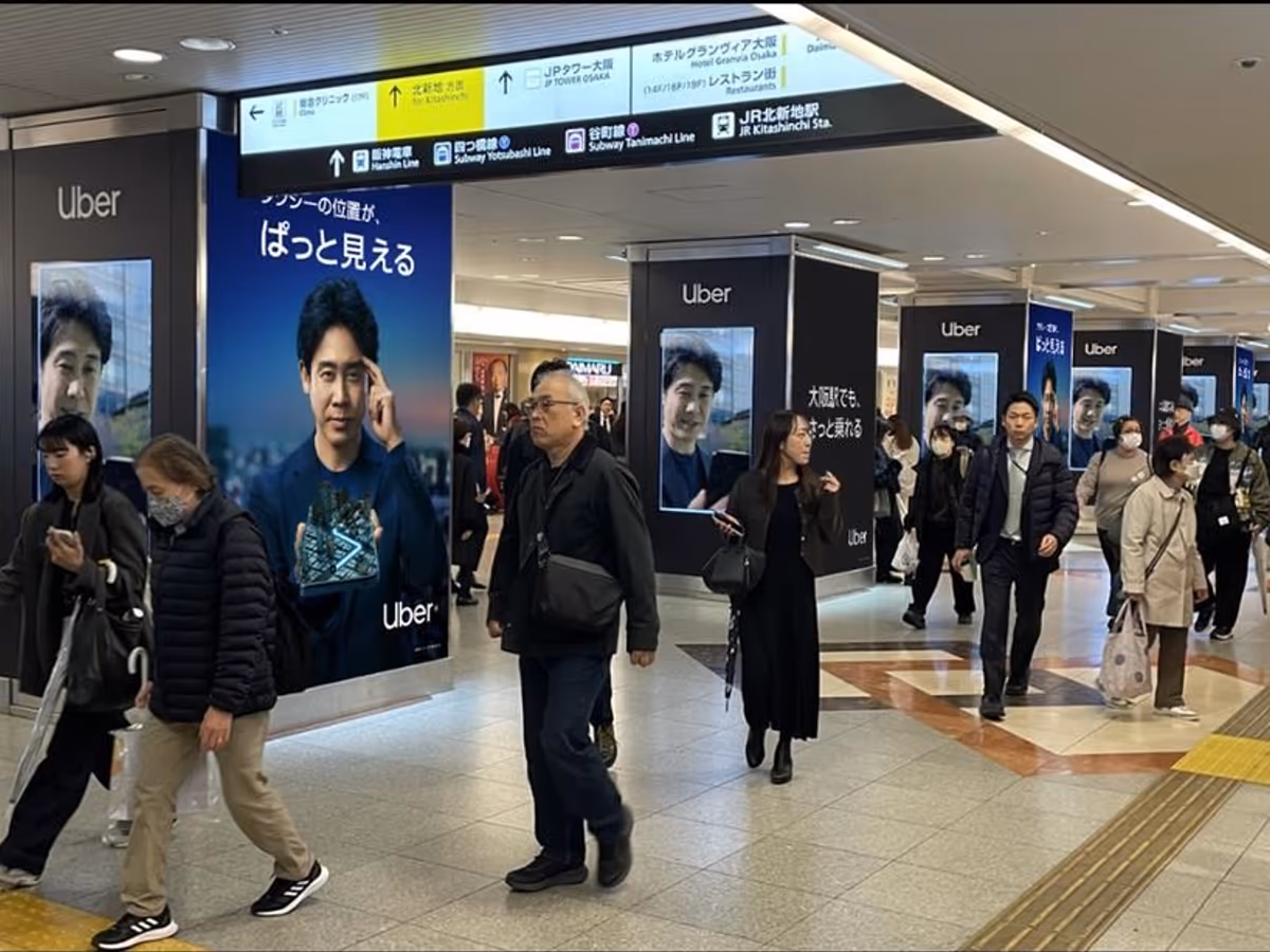 Uber Taxi posters along a busy station concourse